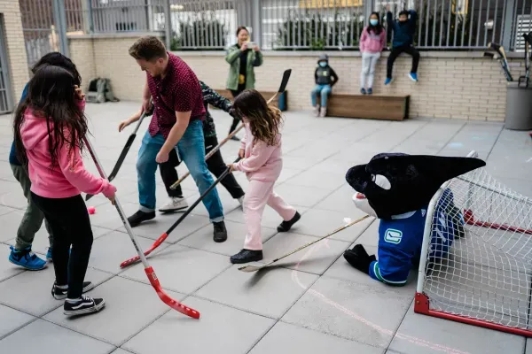 ugm kids eastsiders playing hockey with canucks and outreach worker